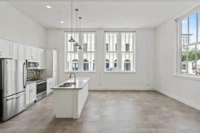 a kitchen with a refrigerator sink and cabinets