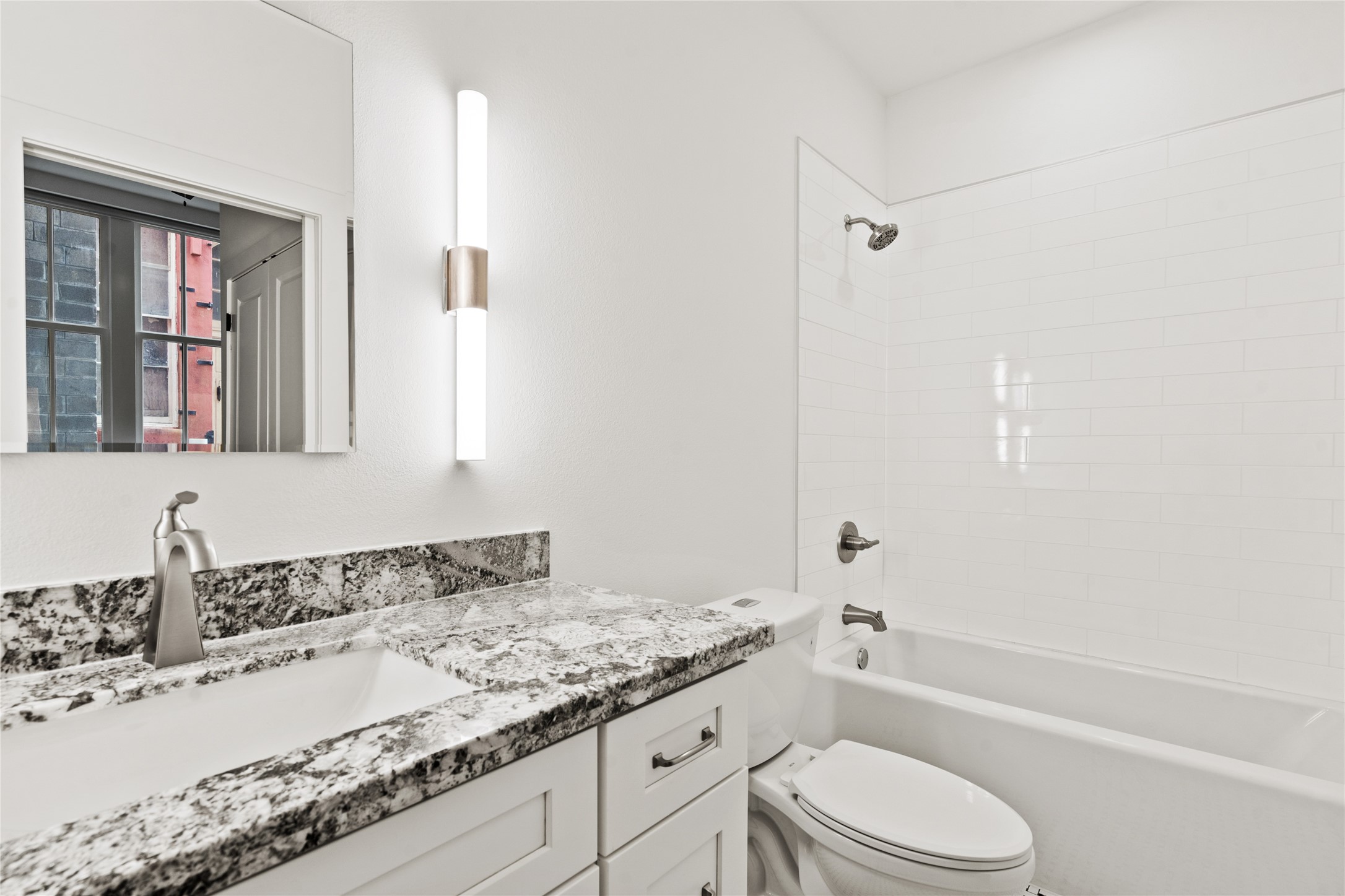 2102 Mechanic Street, Unit 206 Galveston, TX 77550 - Photo 19 of 22 a bathroom with a granite countertop sink toilet and shower