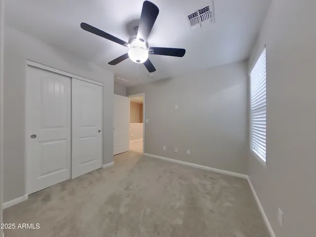an empty room with chandelier fan