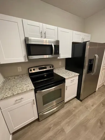 a kitchen with stainless steel appliances granite countertop a stove microwave and refrigerator