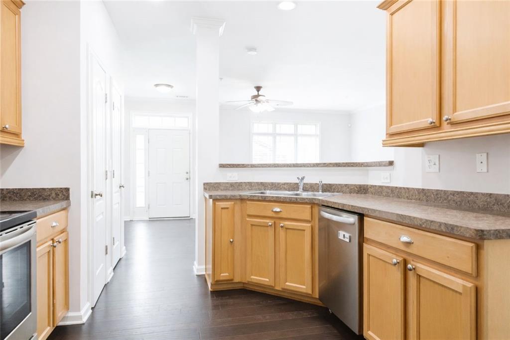 544 Ridge View Crossing Woodstock, GA 30188 - Photo 10 of 30 a kitchen with stainless steel appliances granite countertop a sink and cabinets with wooden floor