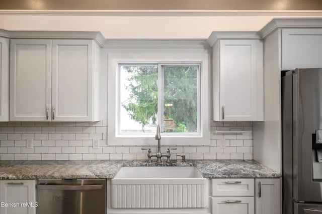 a kitchen with stainless steel appliances granite countertop a sink stove and refrigerator