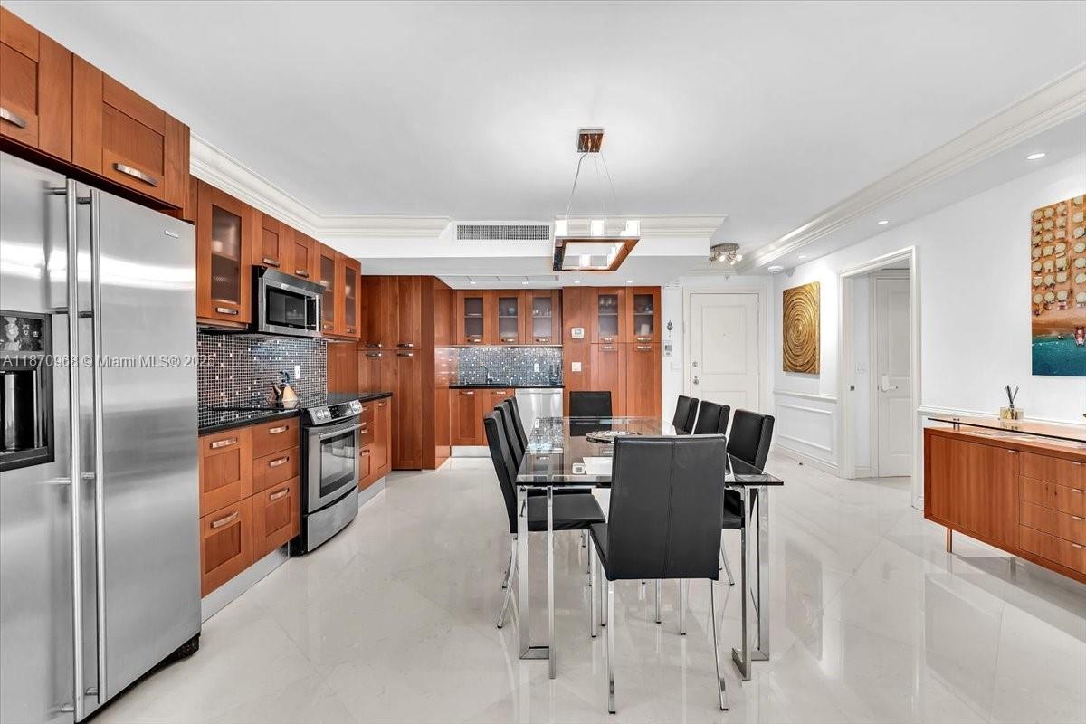9801 Collins Avenue, Unit 4Y Bal Harbour, FL 33154 - Photo 13 of 71 a kitchen with stainless steel appliances granite countertop a refrigerator a stove a sink a dining table and chairs with wooden floor