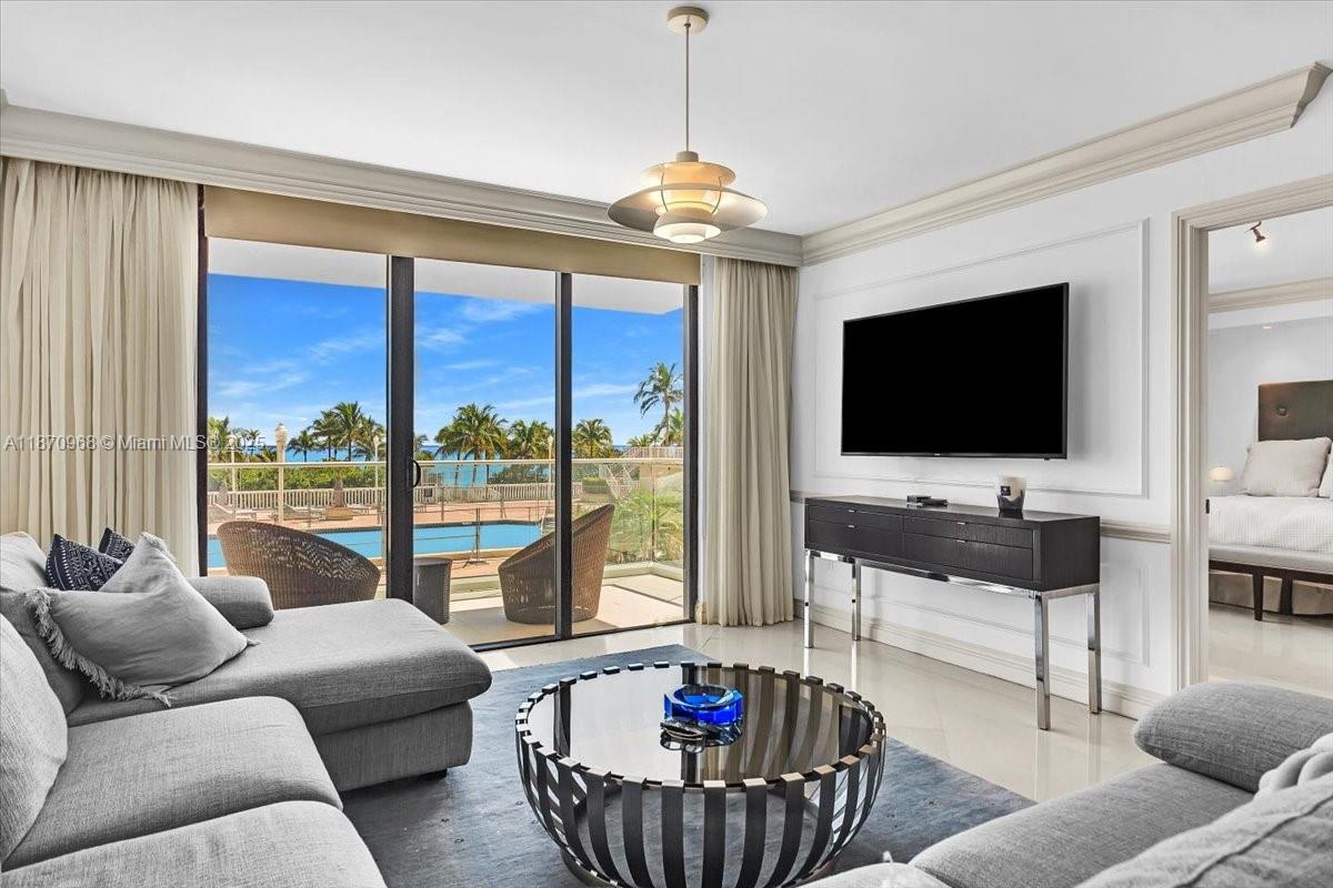9801 Collins Avenue, Unit 4Y Bal Harbour, FL 33154 - Photo 25 of 71 a living room with furniture a flat screen tv and a large window