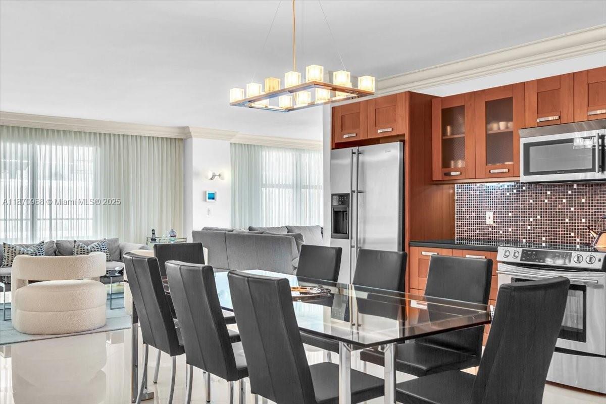 9801 Collins Avenue, Unit 4Y Bal Harbour, FL 33154 - Photo 37 of 71 a view of a dining room with furniture a chandelier and large windows