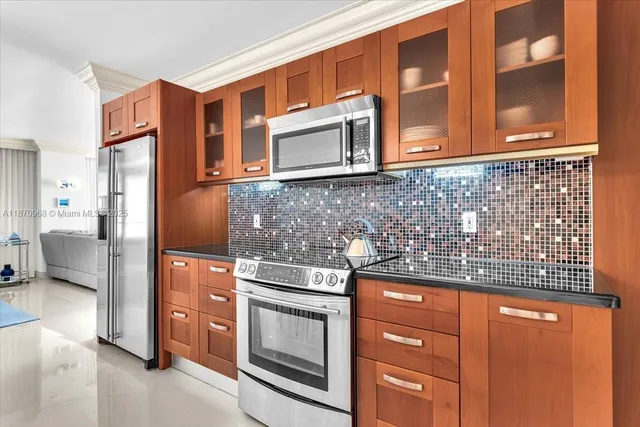 a kitchen with stainless steel appliances granite countertop a refrigerator a stove a sink a dining table and chairs with wooden floor