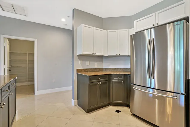 a large kitchen with granite countertop a sink and cabinets with wooden floor