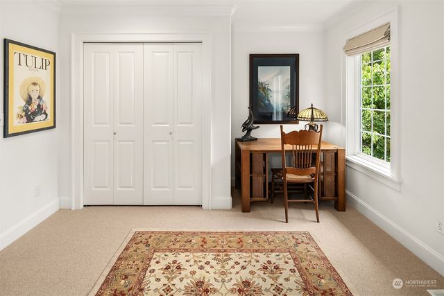 a view of a workspace with furniture and a window