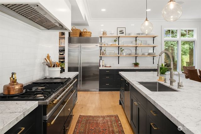 a kitchen with stainless steel appliances granite countertop a sink stove and cabinets