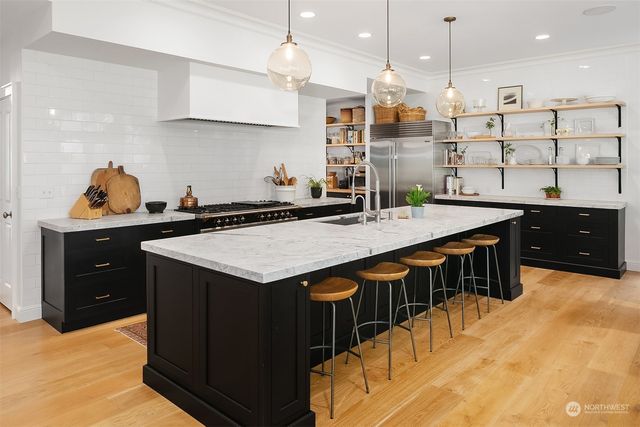 a kitchen with stainless steel appliances granite countertop a stove a sink and a refrigerator