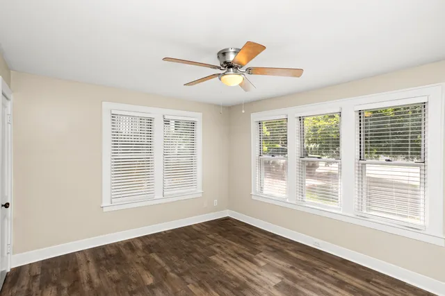 a view of an empty room with a window and a ceiling fan