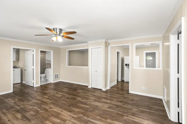 an empty room with wooden floor and a ceiling fan