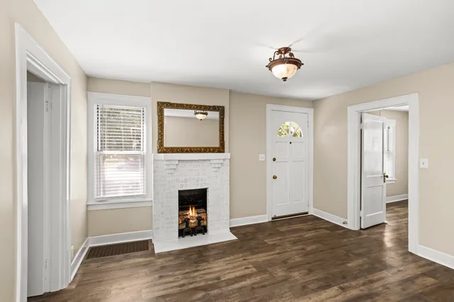 a view of an empty room with a window and a fireplace