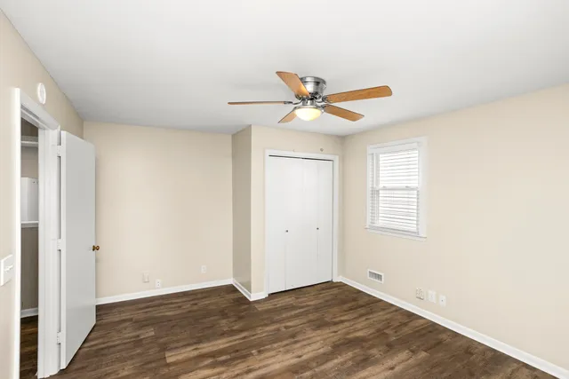a view of a big room with wooden floor and a ceiling fan
