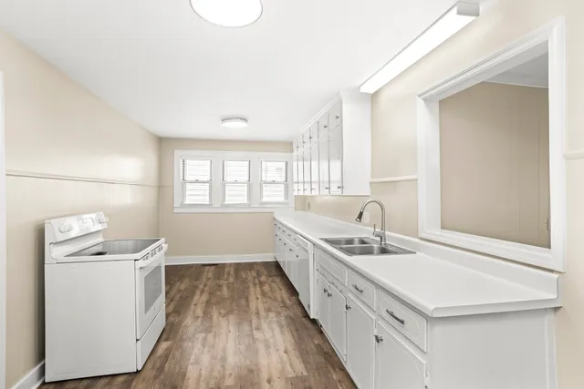 a kitchen with a sink stove and cabinets