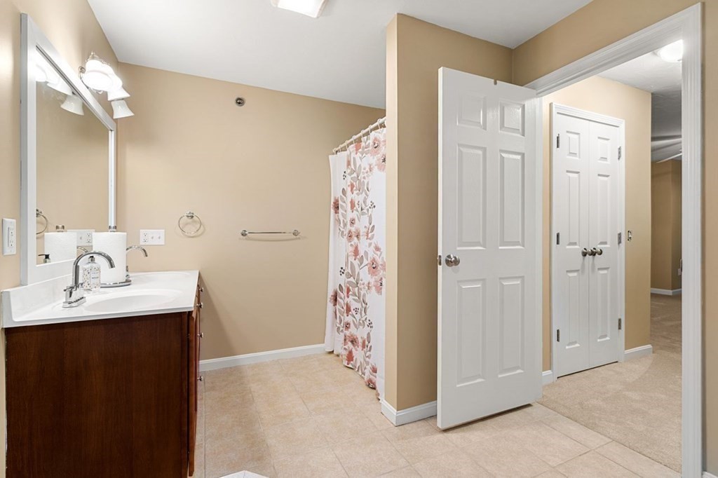 21 Conover Way, Unit 21 Haverhill, MA 01835 - Photo 14 of 31 a bathroom with a shower sink and mirror