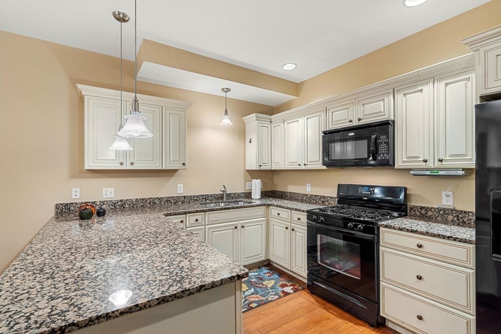 21 Conover Way, Unit 21 Haverhill, MA 01835 - Photo 6 of 31 a kitchen with granite countertop a sink cabinets stainless steel appliances and a counter space