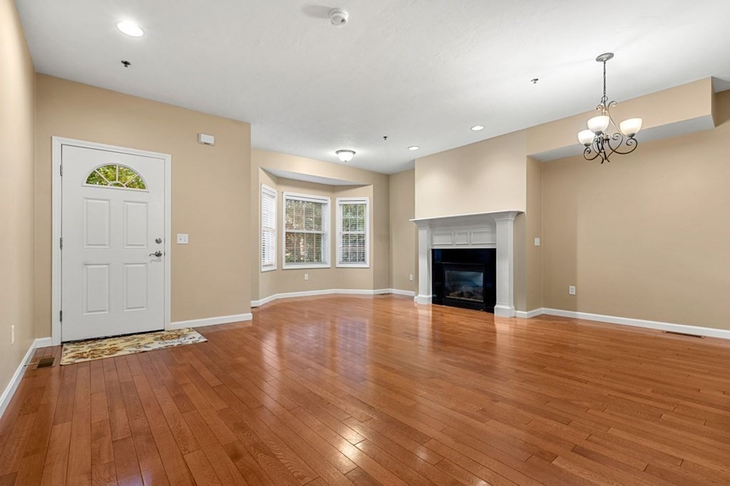21 Conover Way, Unit 21 Haverhill, MA 01835 - Photo 9 of 31 an empty room with wooden floor fireplace and window