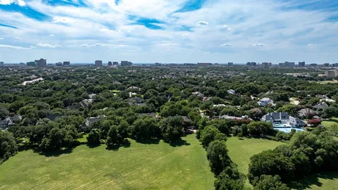 an aerial view of residential houses with outdoor space and trees