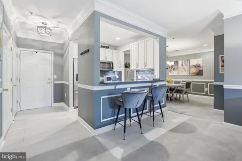 a large dining hall with stainless steel appliances kitchen island granite countertop a table chairs and a sink