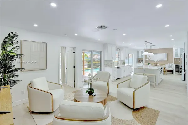 a kitchen with stainless steel appliances kitchen island granite countertop a table chairs and a refrigerator