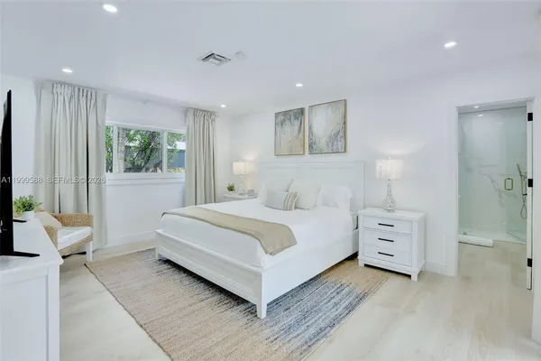 a bedroom with a large bed and a window