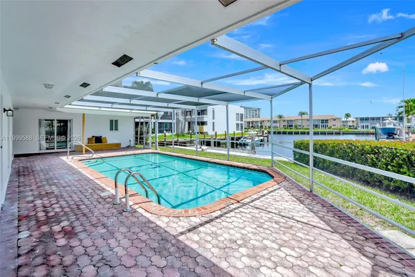a view of a swimming pool with a lounge chairs in front of a house