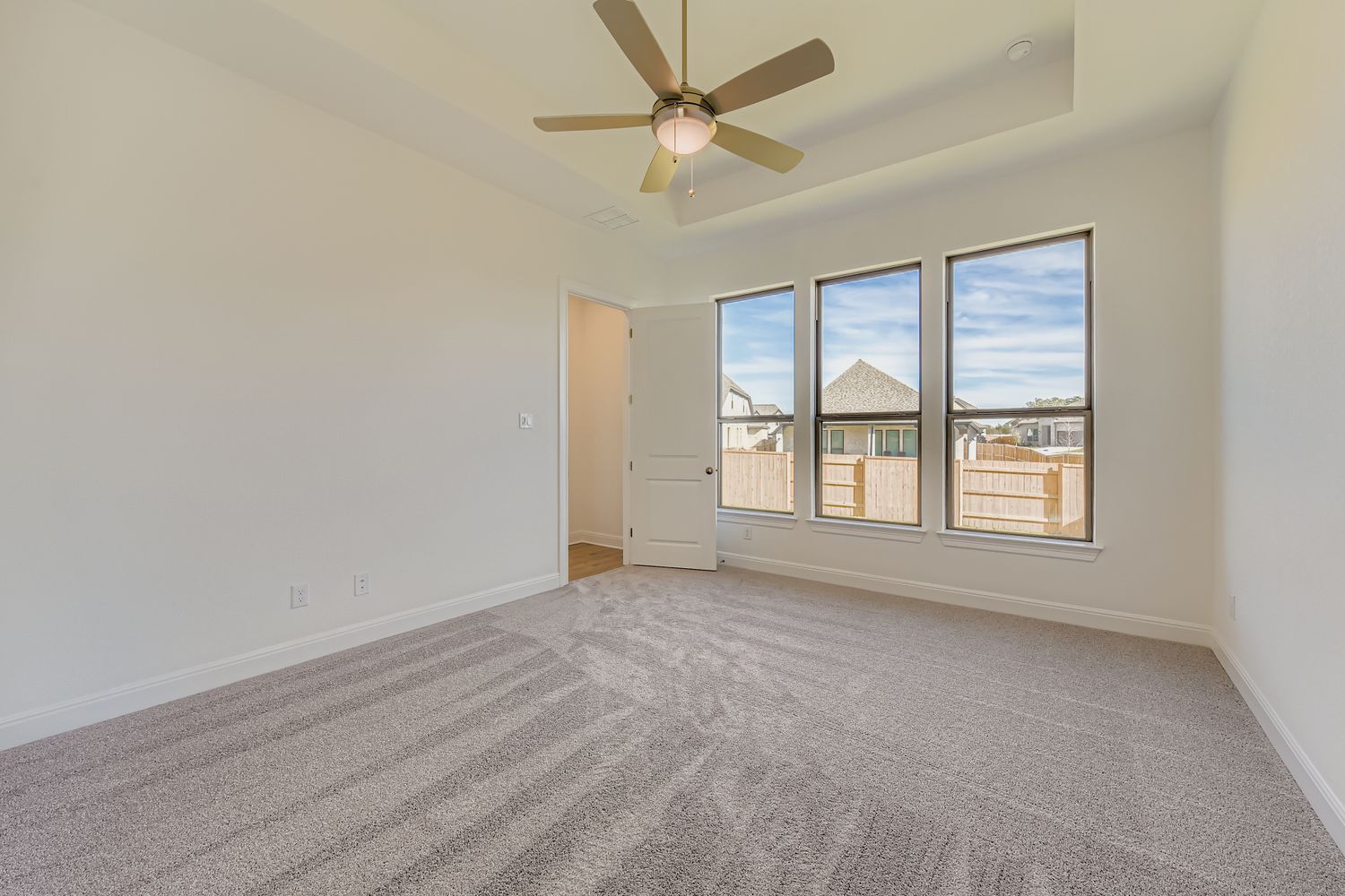 395 Prickly Poppy Loop Kyle, TX 78640 - Photo 6 of 11 an empty room with chandelier fan and windows