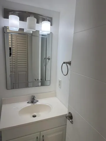 a bathroom with a sink vanity and mirror