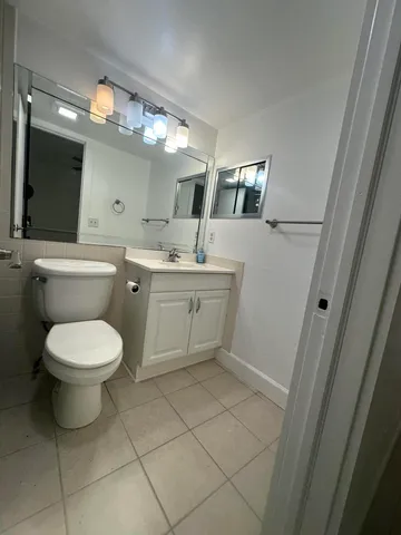 a spacious bathroom with a toilet sink and mirror