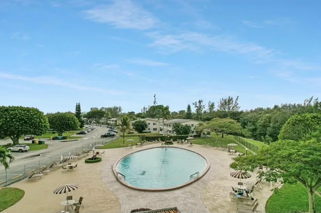 an aerial view of a house with outdoor space and trees all around