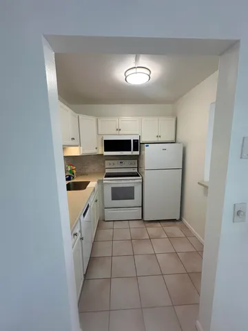 a kitchen with a cabinets and white appliances