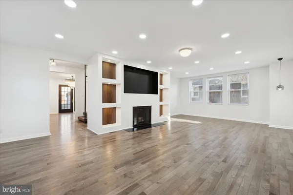 a view of a livingroom with a fireplace wooden floor and window