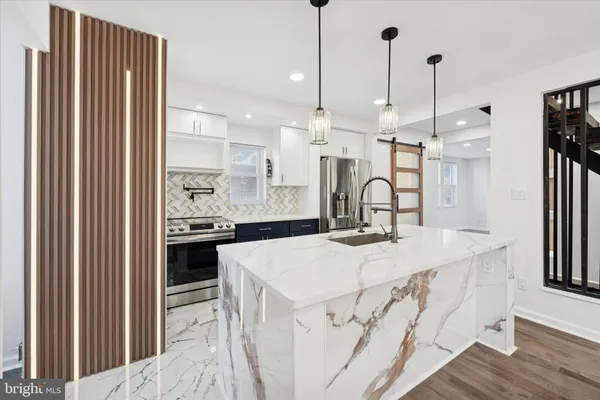a kitchen with kitchen island a sink stove and wooden floor
