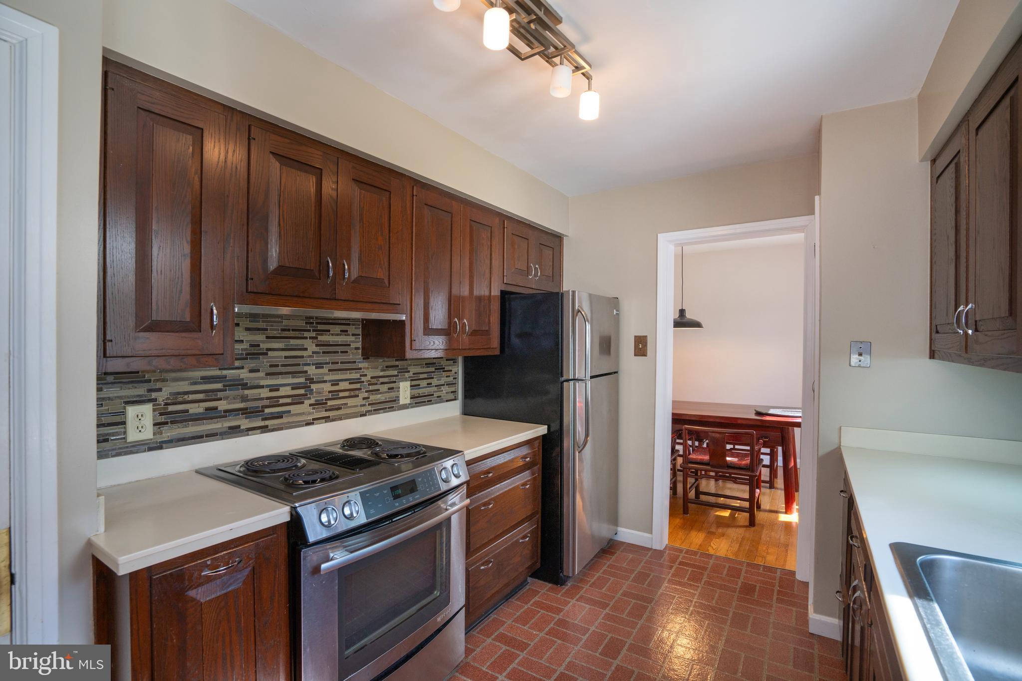 422 Martin Terrace State College, PA 16803 - Photo 5 of 56 a kitchen with stainless steel appliances granite countertop a stove top oven a refrigerator and a dining table with wooden floor