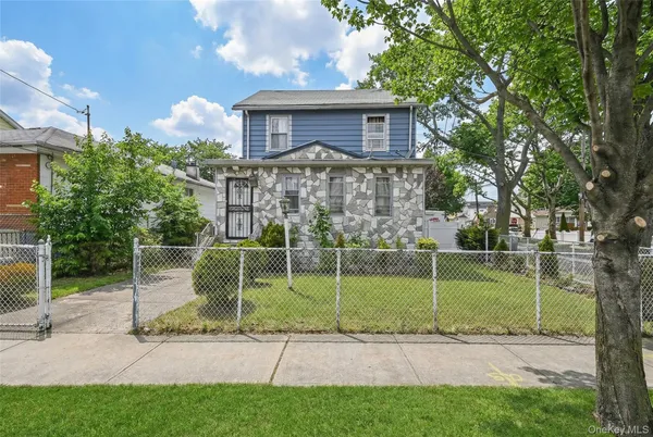 a view of a house with a backyard and a tree