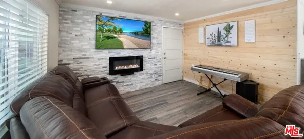 a living room with furniture a flat screen tv and a fireplace