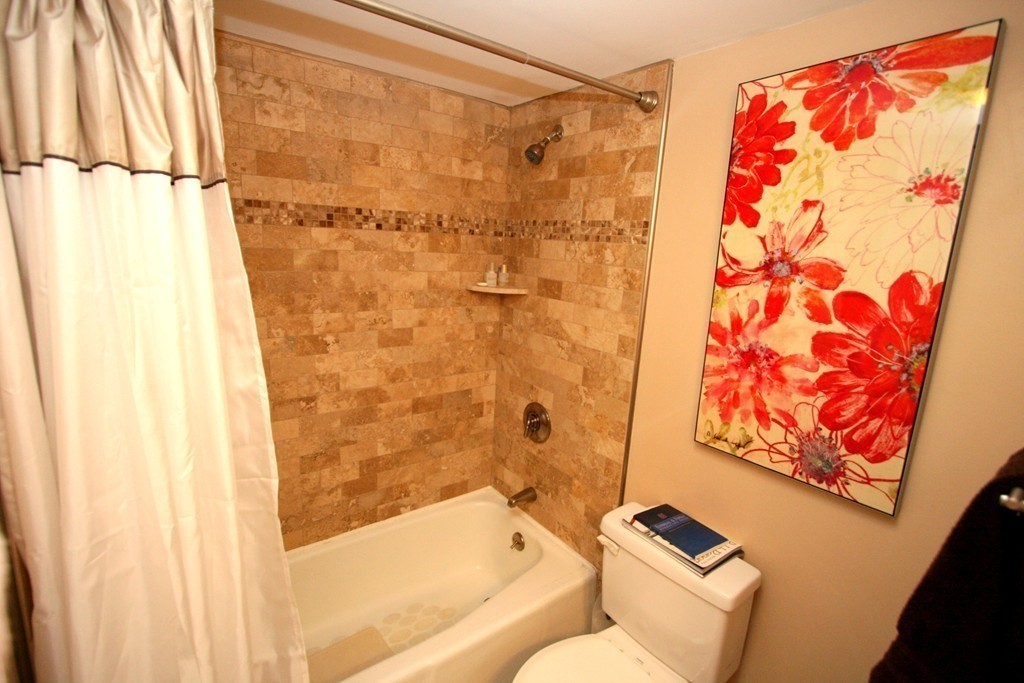 85 Brainerd Road, Unit 510 Boston, MA 02134 - Photo 10 of 25 a bathroom with a shower curtain and a bathtub