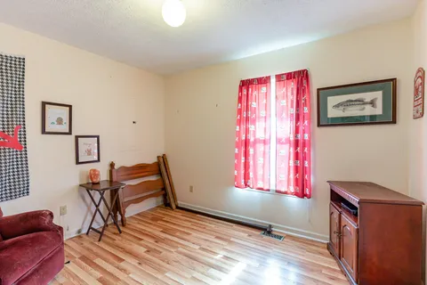 a living room with furniture a air conditioner vent and a window