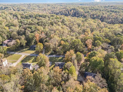 an aerial view of residential house with yard and mountain view in back