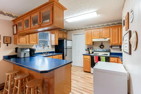 a kitchen with stainless steel appliances granite countertop a sink a stove and refrigerator