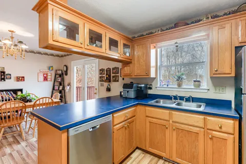 a kitchen with stainless steel appliances granite countertop a sink dishwasher and cabinets with wooden floor
