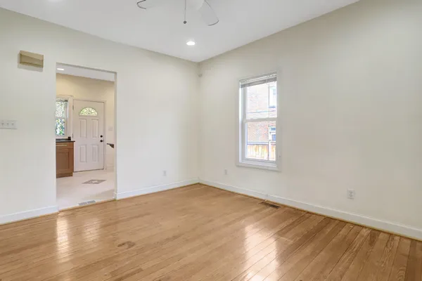an empty room with wooden floor and windows