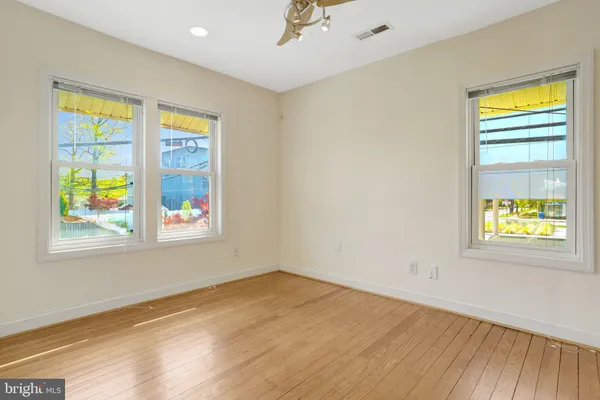 an empty room with closet and a ceiling fan
