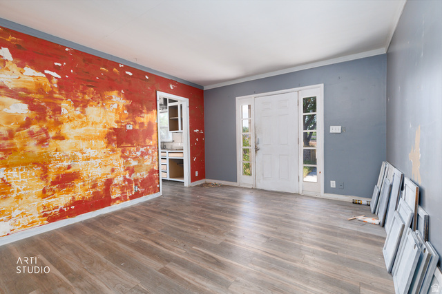 330 West 600th Street South Provo, UT 84601 - Photo 8 of 26 Open-concept interior featuring wood-finish flooring, a white paneled entry door with sidelights, and visible kitchen cabinetry through an interior doorway
