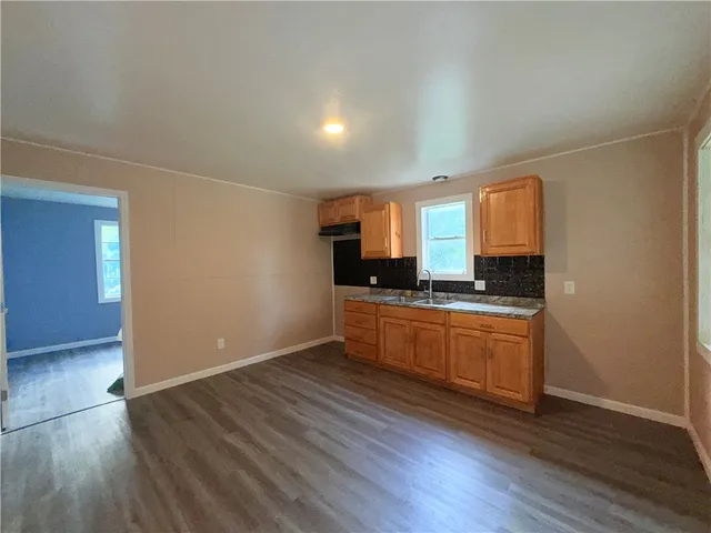 a kitchen with granite countertop a sink and a stove top oven