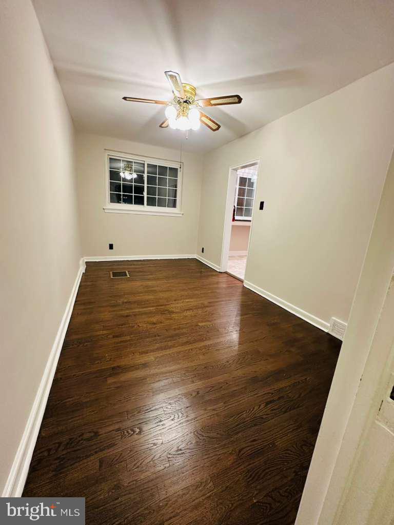 8509 Temple Road Philadelphia, PA 19150 - Photo 5 of 16 an empty room with wooden floor chandelier fan and windows