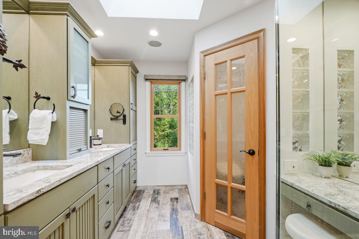 9804 Korman Court Potomac, MD 20854 - Photo 36 of 66 a bathroom with a granite countertop double vanity sink a mirror and a shower