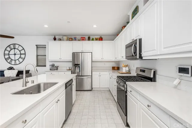 a kitchen with white cabinets and refrigerator