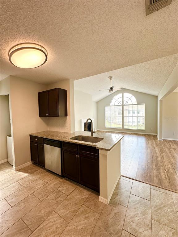654 Roaring Drive, Unit 228 Altamonte Springs, FL 32714 - Photo 13 of 37 a large kitchen with stainless steel appliances granite countertop a sink and a stove next to a window